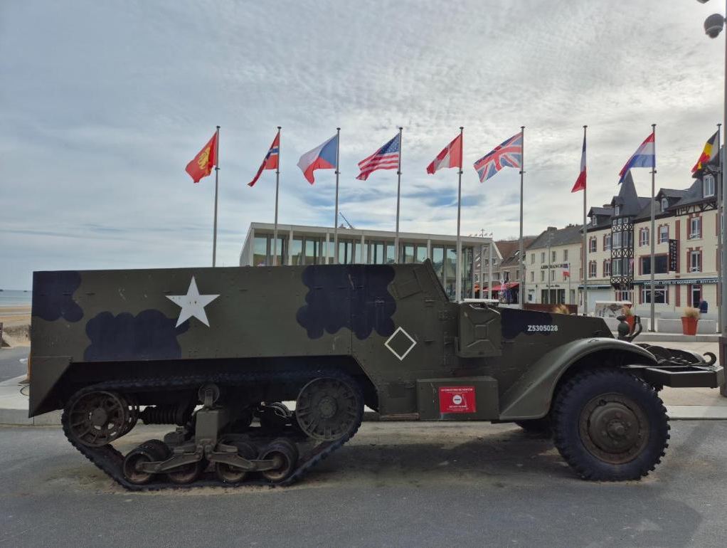 A wartime half-track under the flags